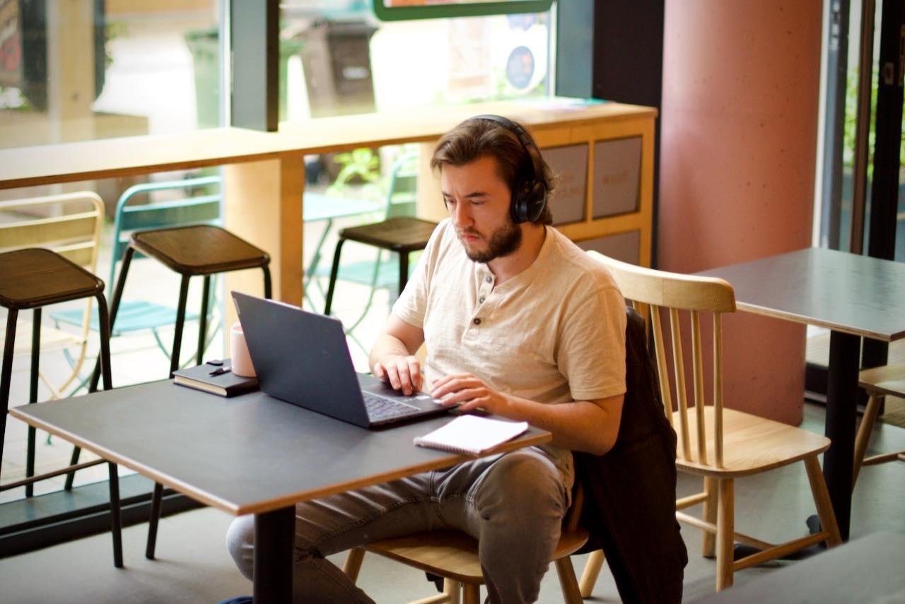 Matt working at his laptop in a coffee shop